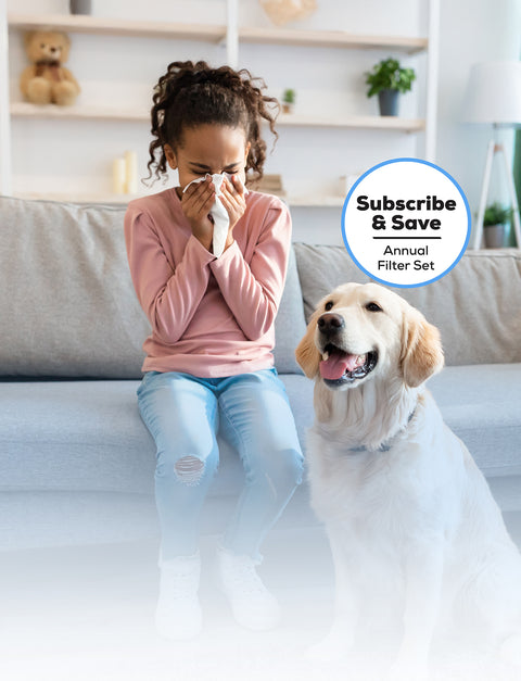 Young girl sneezing on the couch with a brown dog to her right and a blue outlined subscribe and save bubble above the dog.