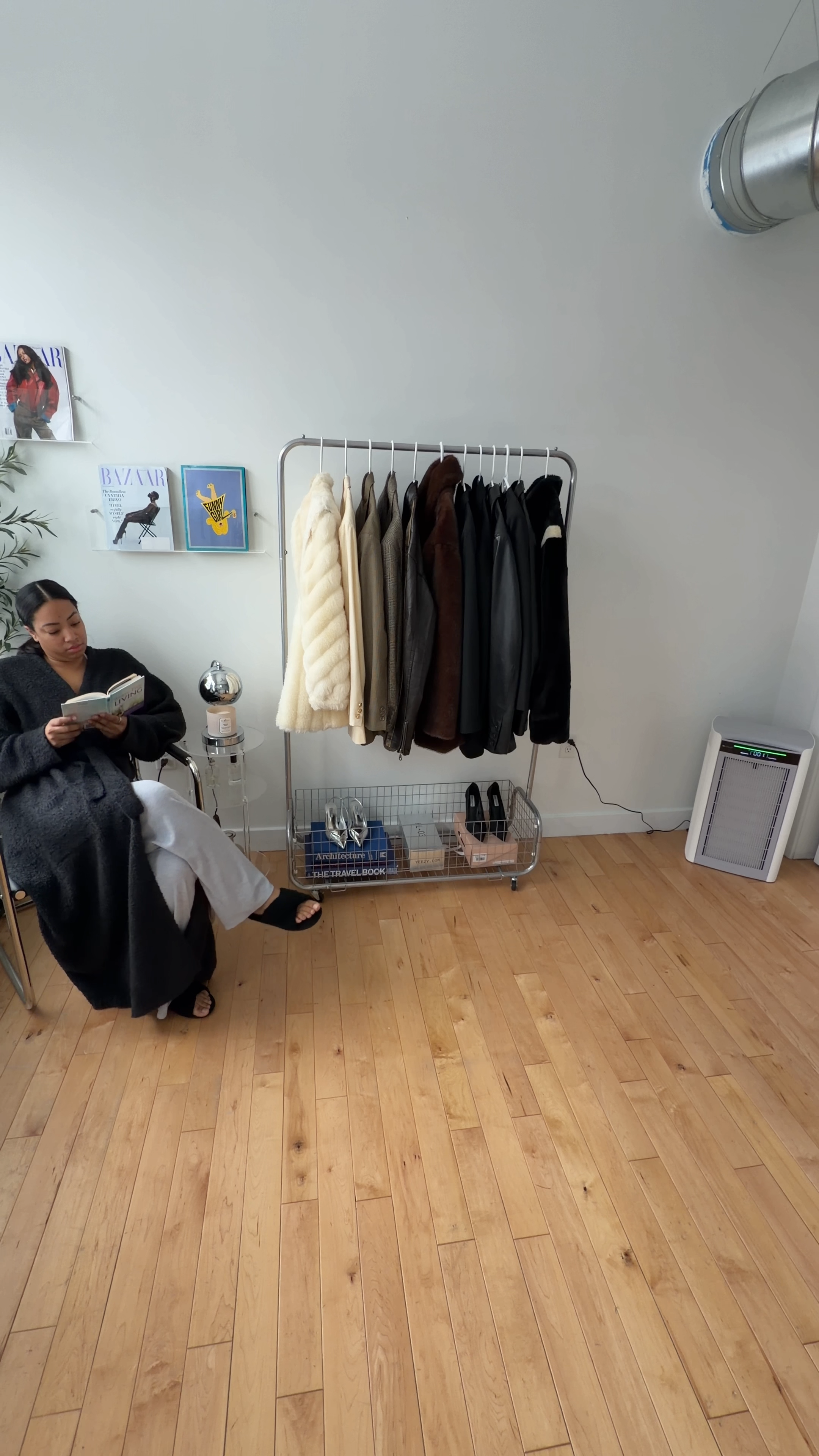Women reading a book near a clothes rack and an H1000 air purifier