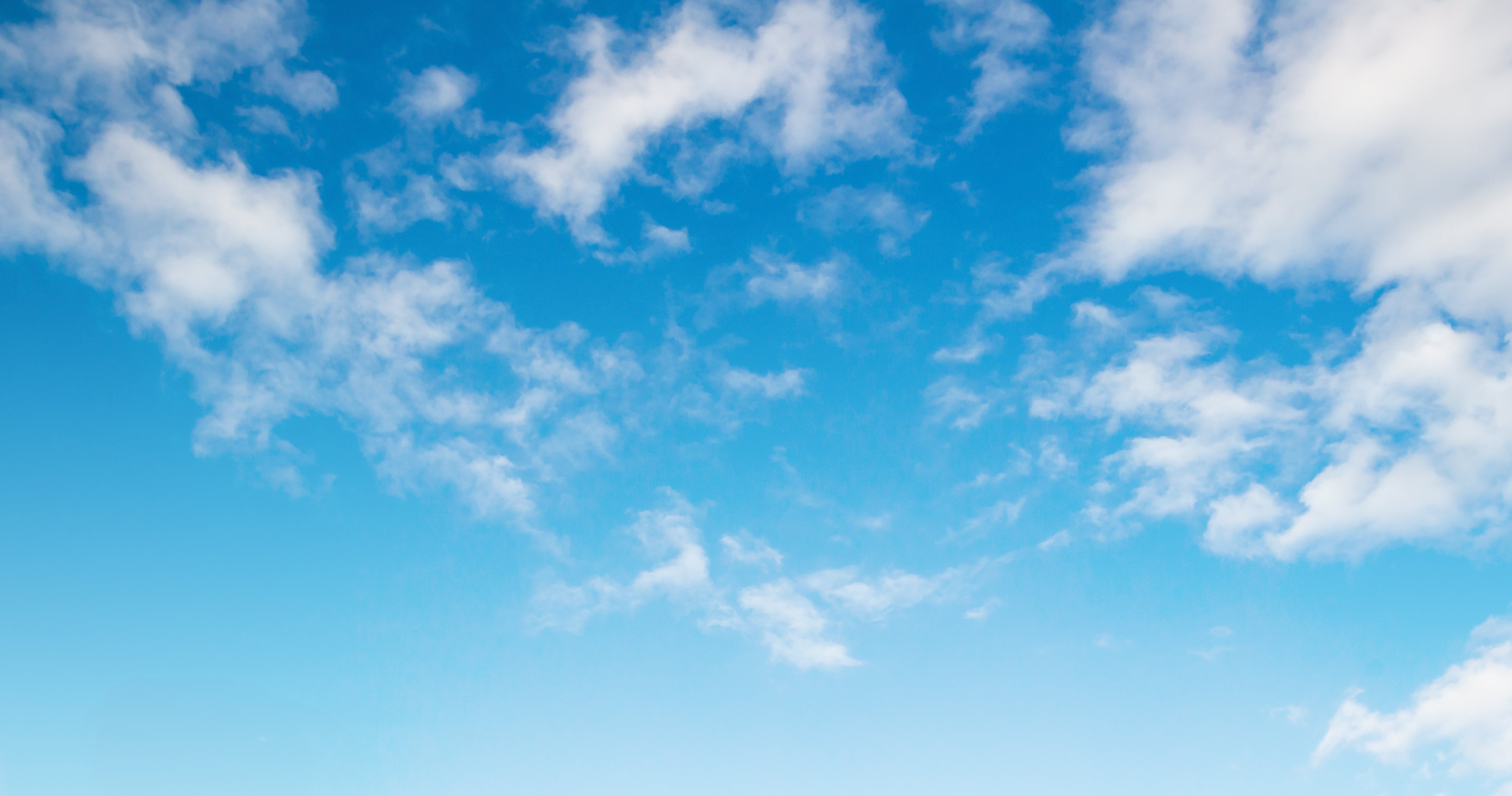 Clear blue sky with scattered white clouds