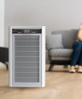 Air purifier on a wooden floor with a blurred background of a living room.