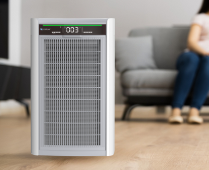 Air purifier on a wooden floor with a blurred background of a living room.