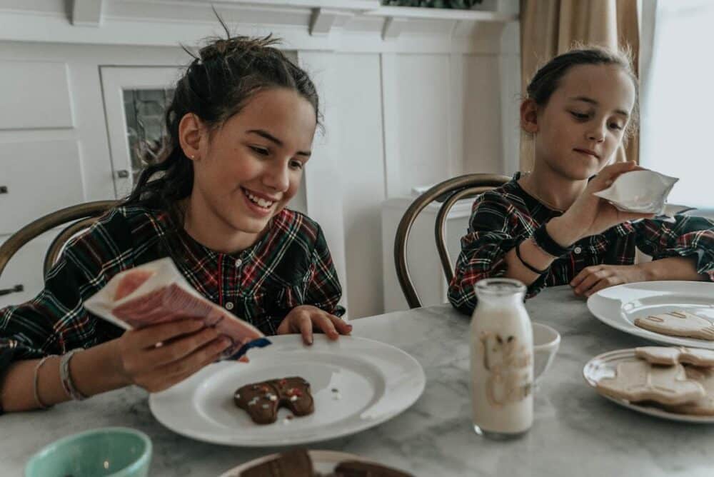Close up of two girls decorating Christmas cookies with an UltraFine-468 in the background